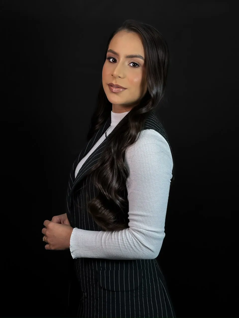 Dra. Cláudia Calixto, de perfil, em fundo escuro
